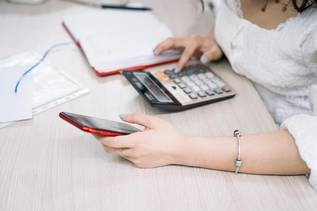 A person using a calculator and a smartphone