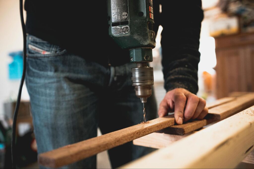 Man drilling into wood plank