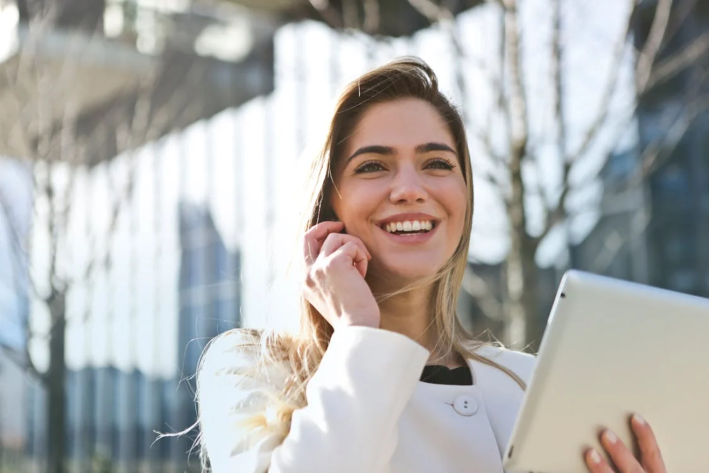 A woman smiling and holding a tablet