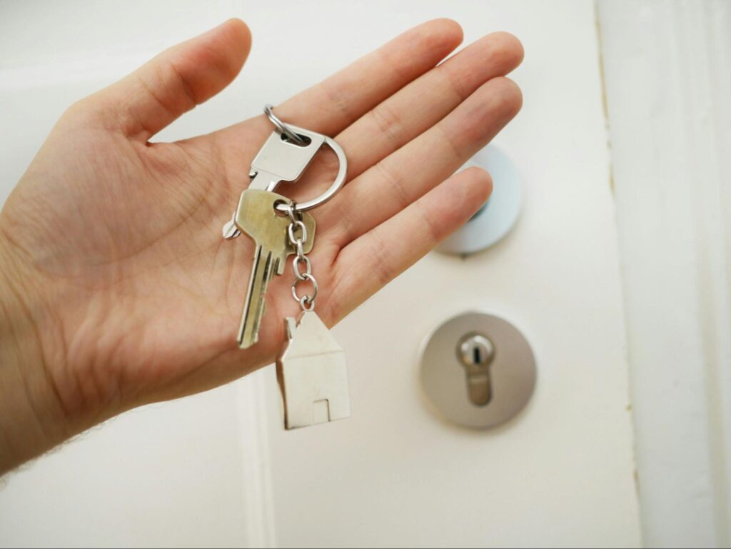 Hand holding keys to home