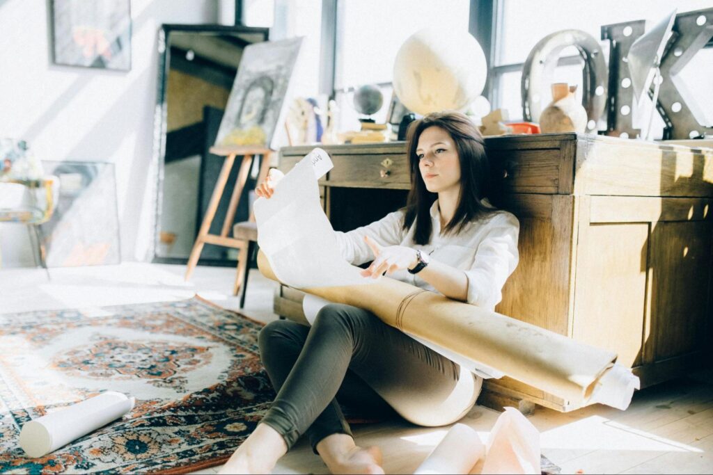 Woman sitting on the floor with papers in her lap