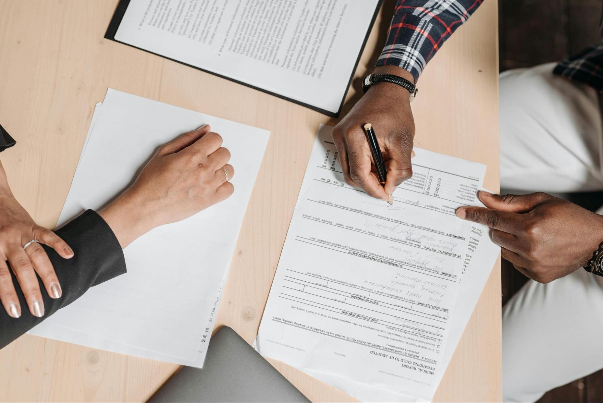 Man signing paperwork on a desk