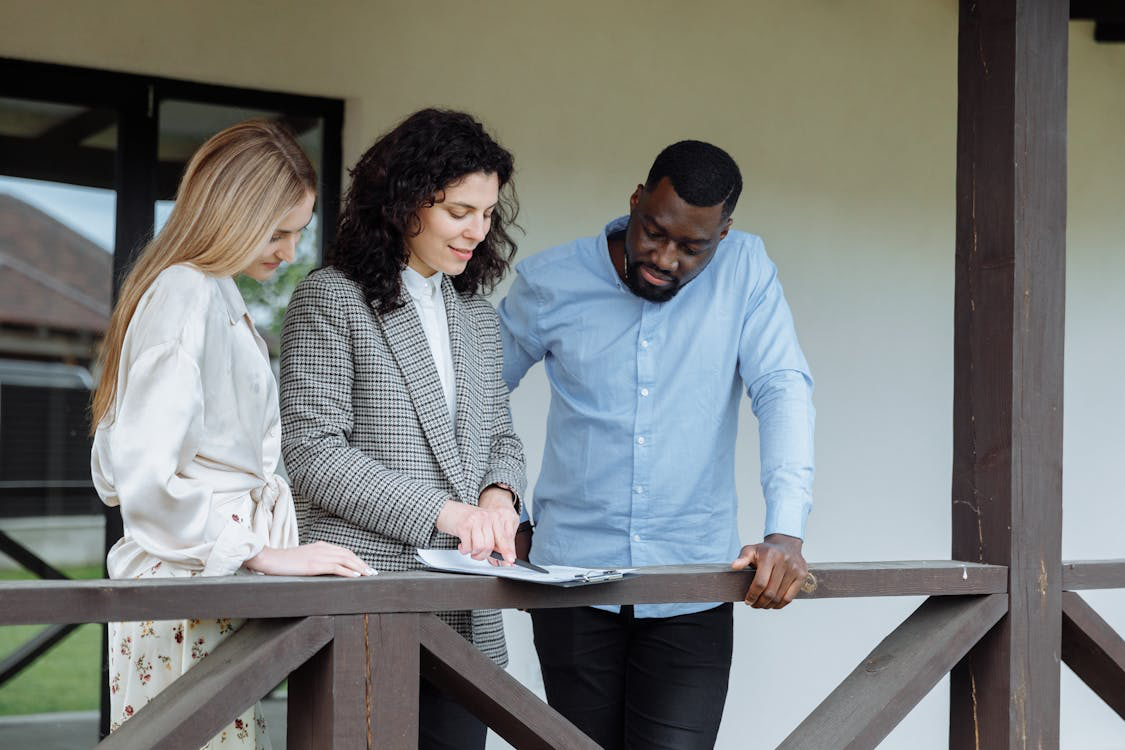 An agent showing two people a document