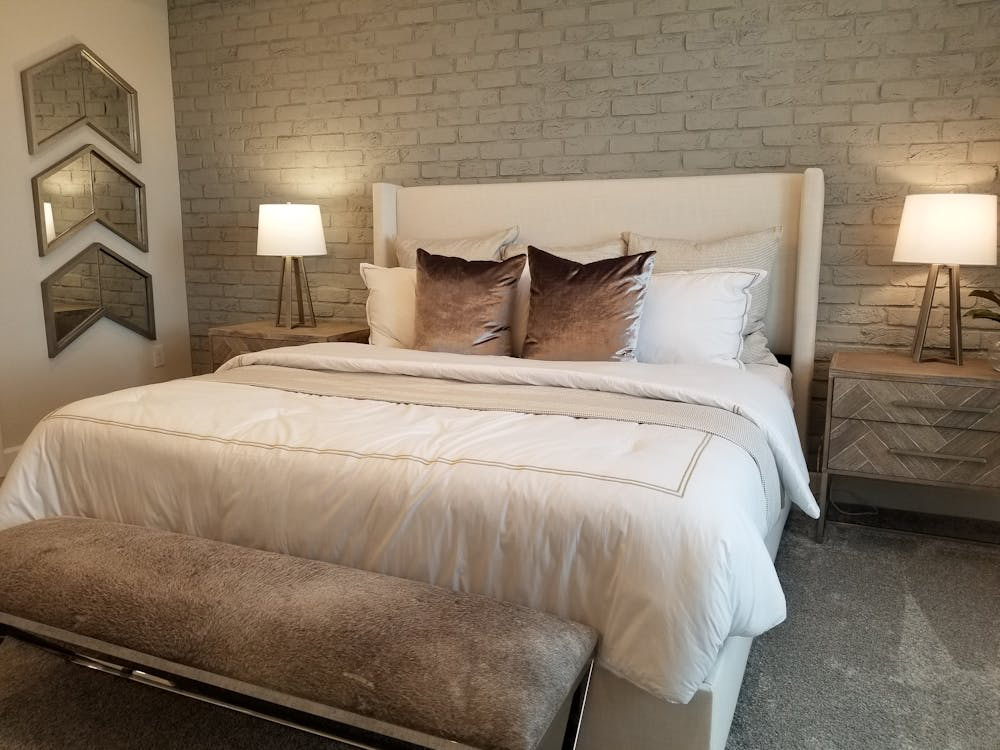 A bedroom with a brick accent wall