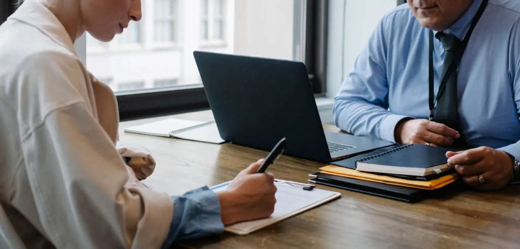 Two people havinga meeting and signing paperwork