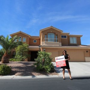 decorative image of annie black holding a for sale sign in front of a house with her phone number